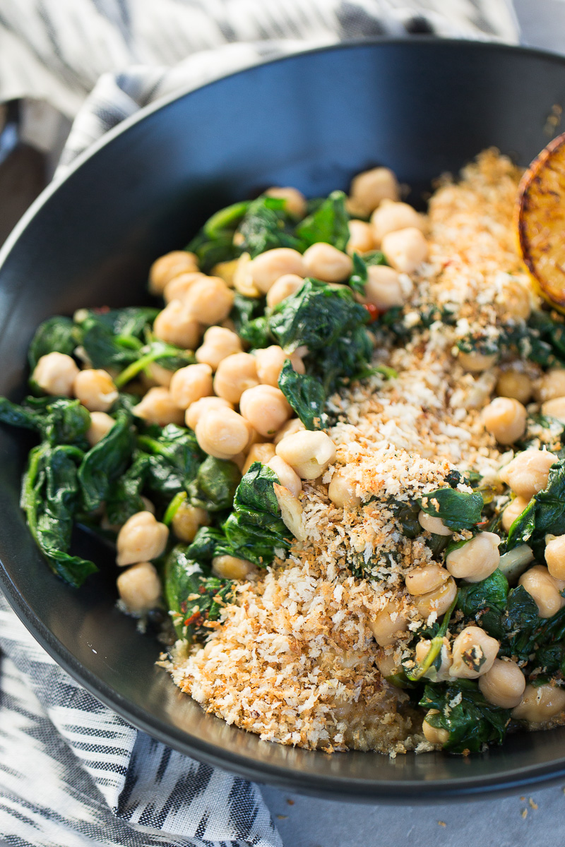 Spinach and chickpeas in a black bowl.