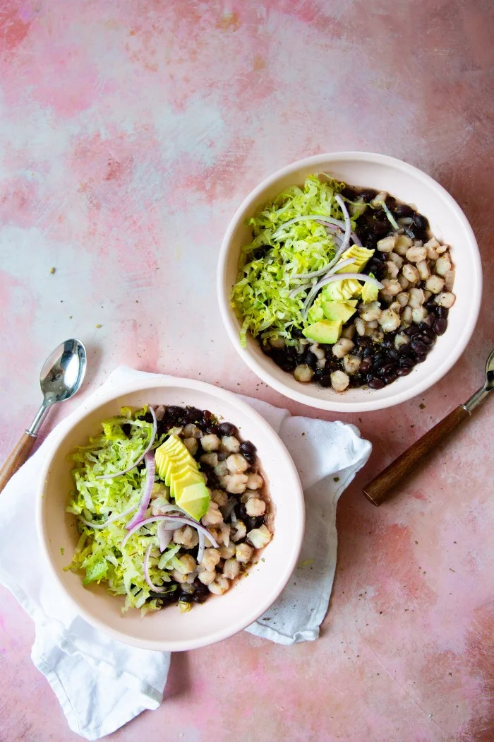 Pozole con frijol negro, aguacate, rabanitos y orégano