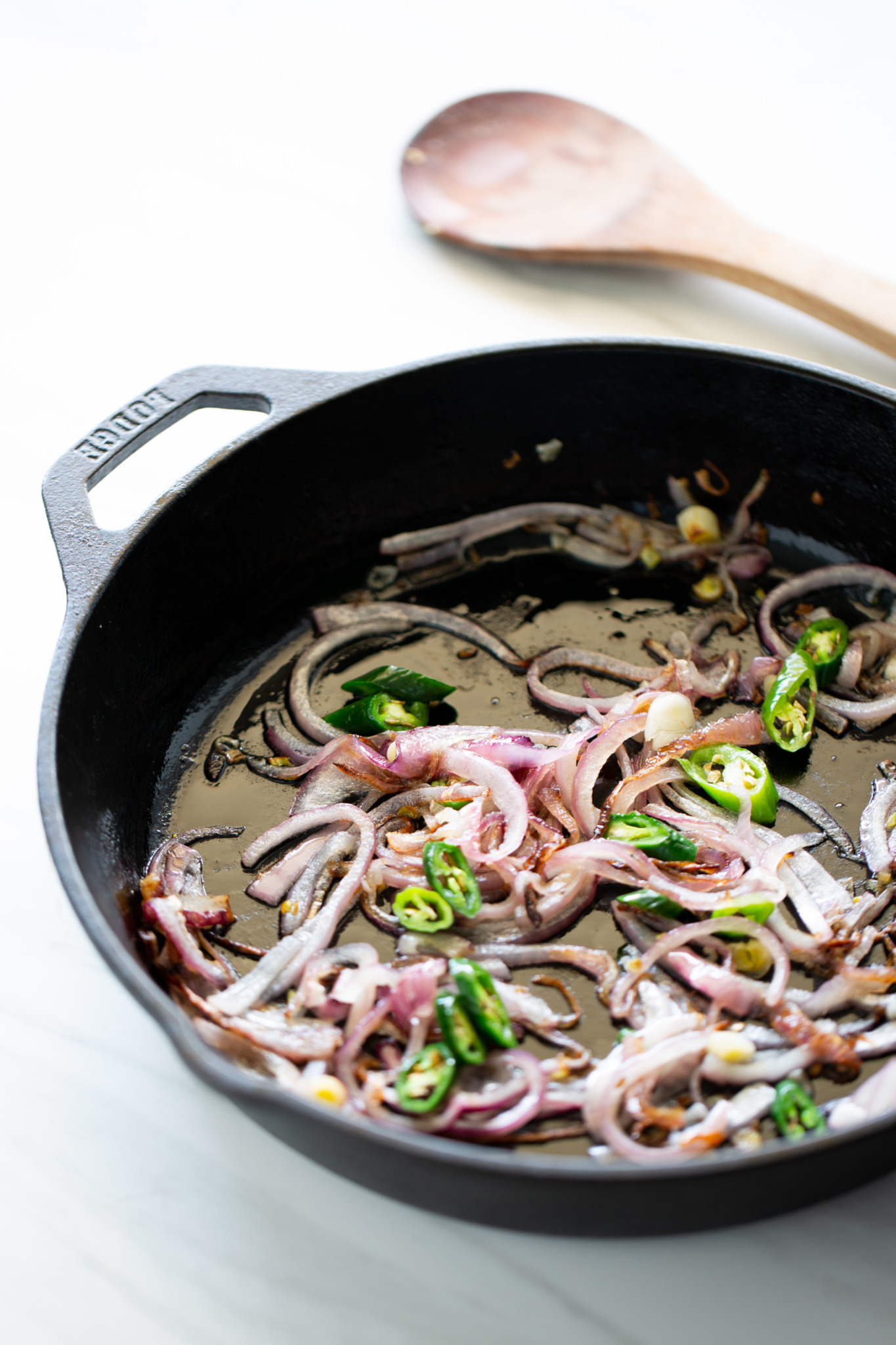 cast iron skillet with sliced onions and chiles