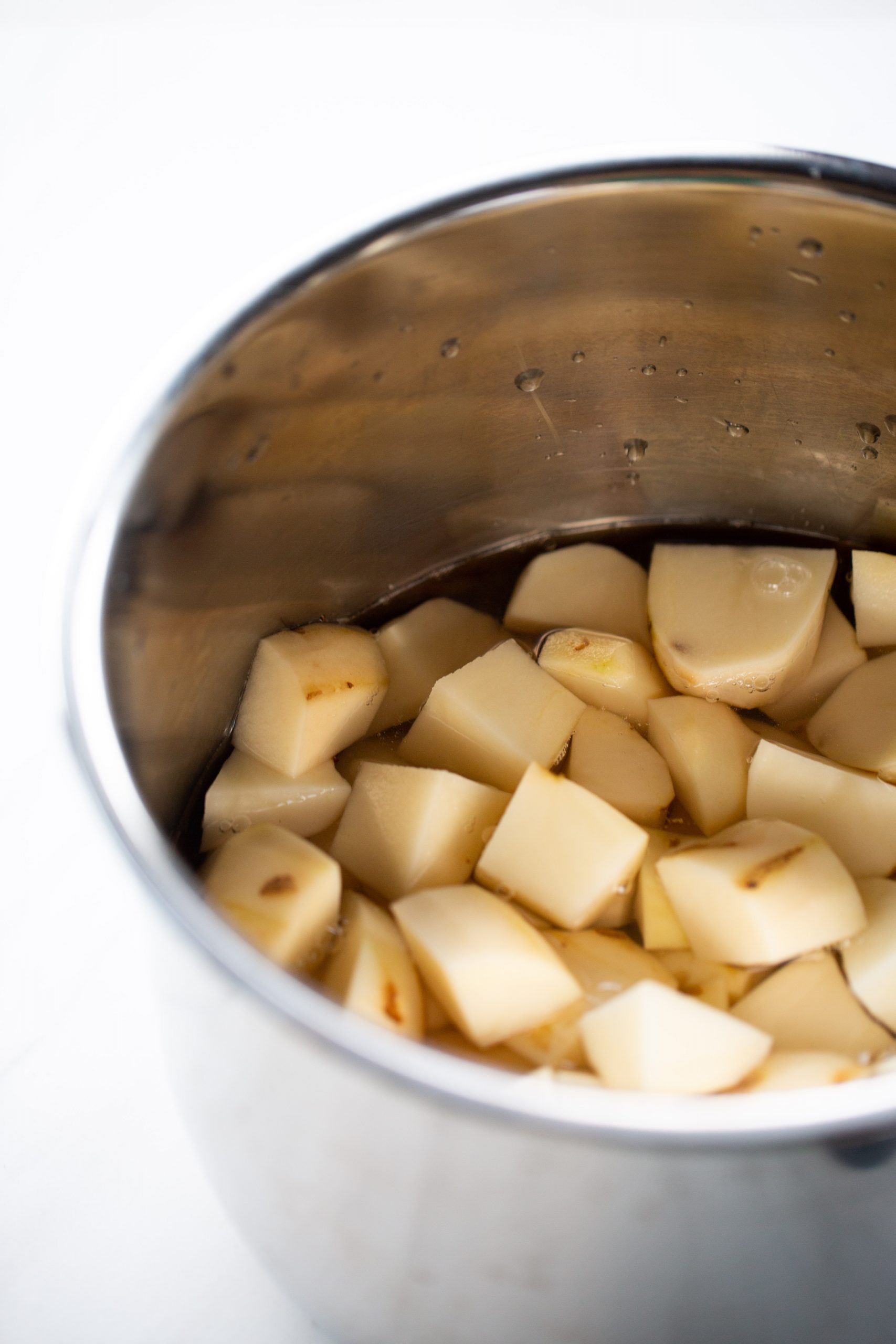 papas en cubos con agua  en una olla 