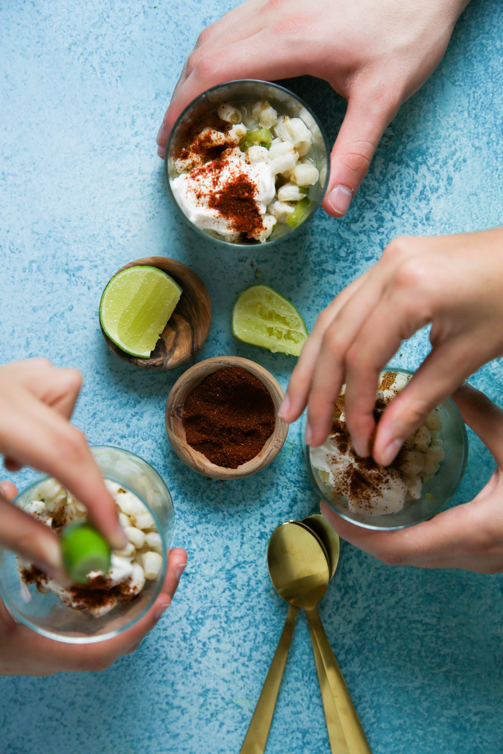 three glasses of esquites with pozole on a blue base 