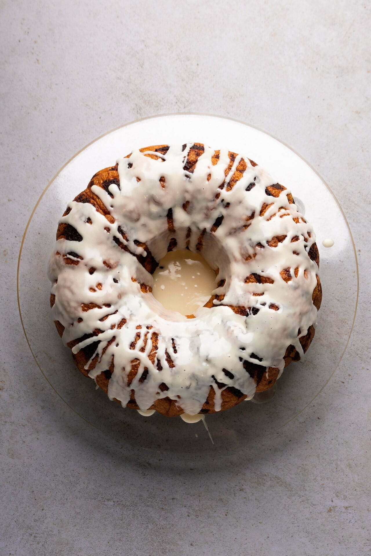 A vegan bundt cake with icing on a plate.