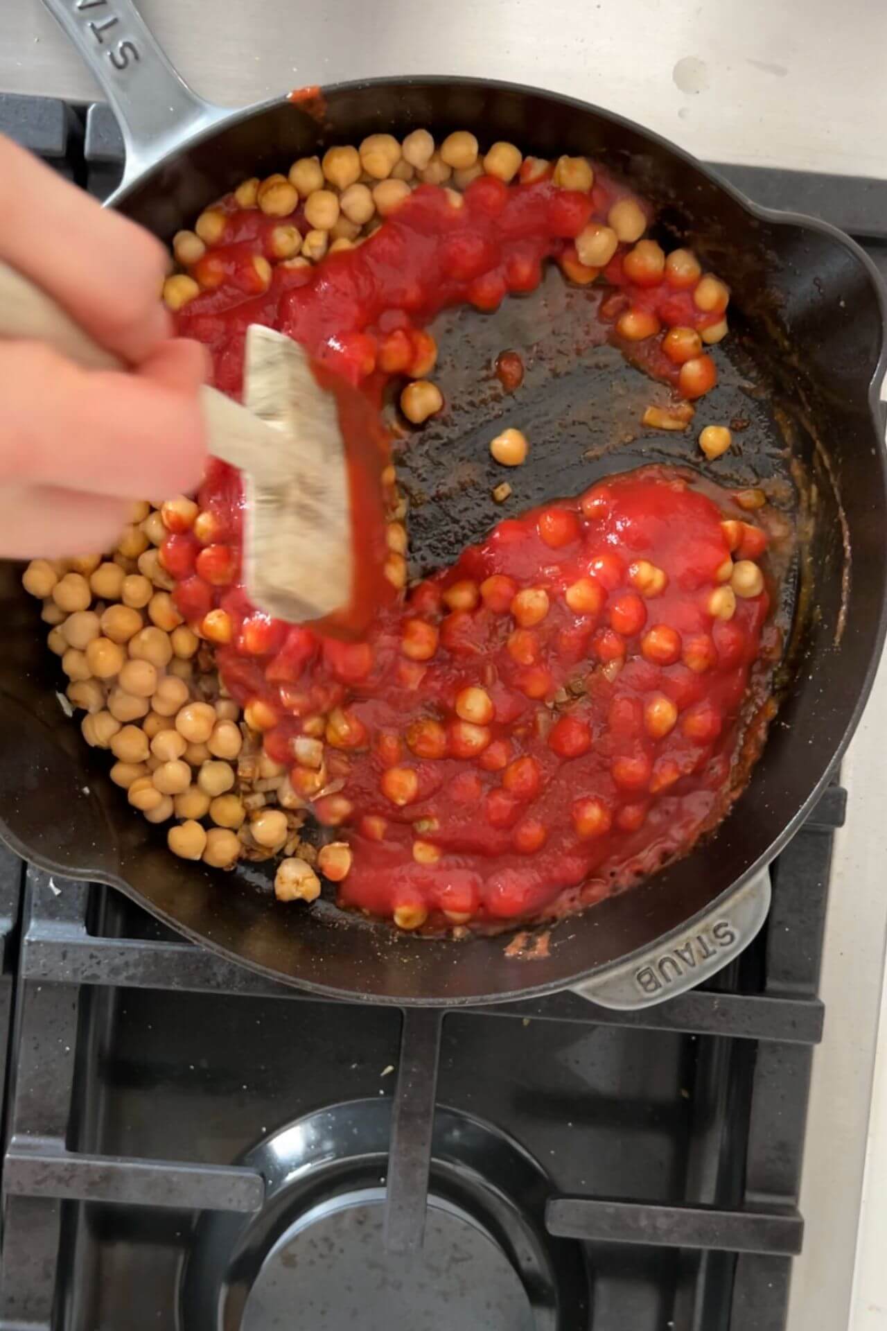 chickpeas and tomatoes on a cast iron pan.