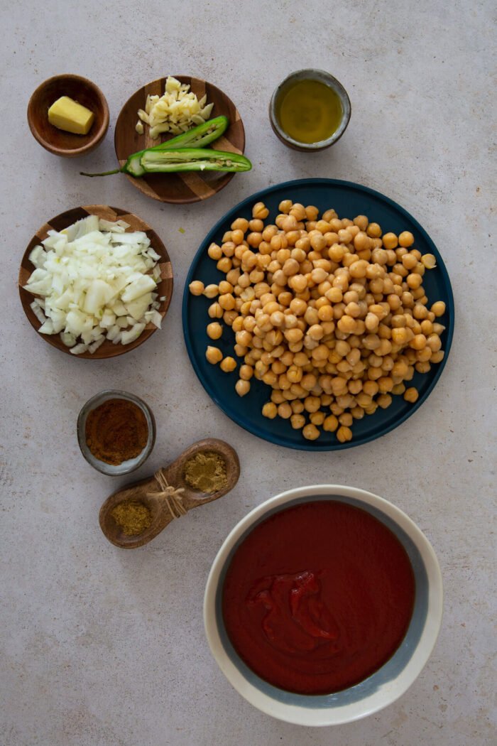 Chickpeas, onions, garlic, ginger, oil, spices and tomato pure, serrano peppers on a mise on place with 