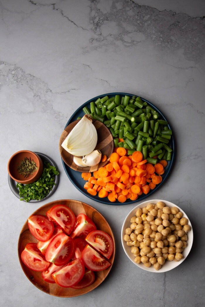 sliced tomatoes, cooked chickpeas, green beans and carrots in pieces, onion and garlic. Ingredients for making caldo tlalpeño without chicken.