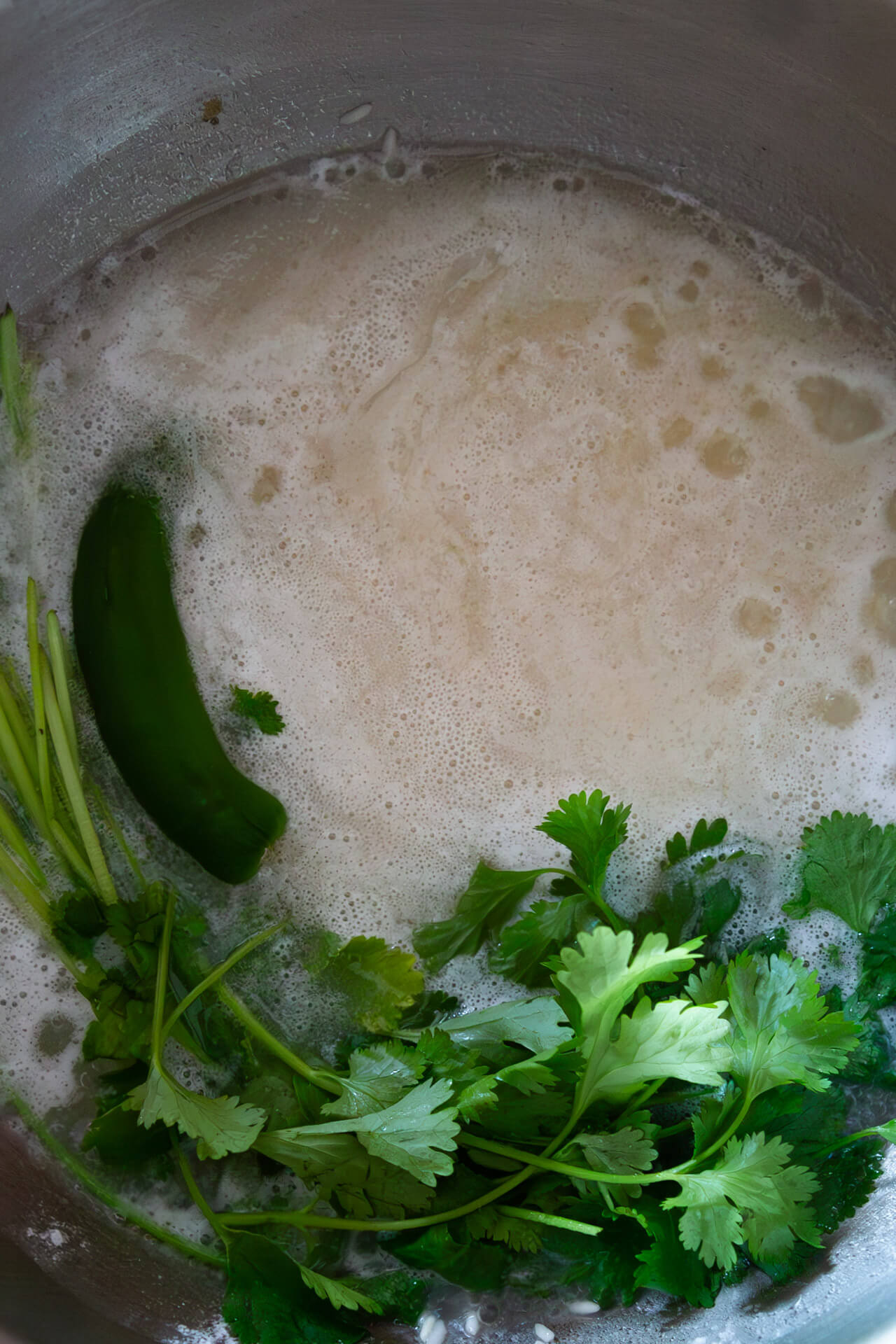 Pot with rice, water cilantro and onion