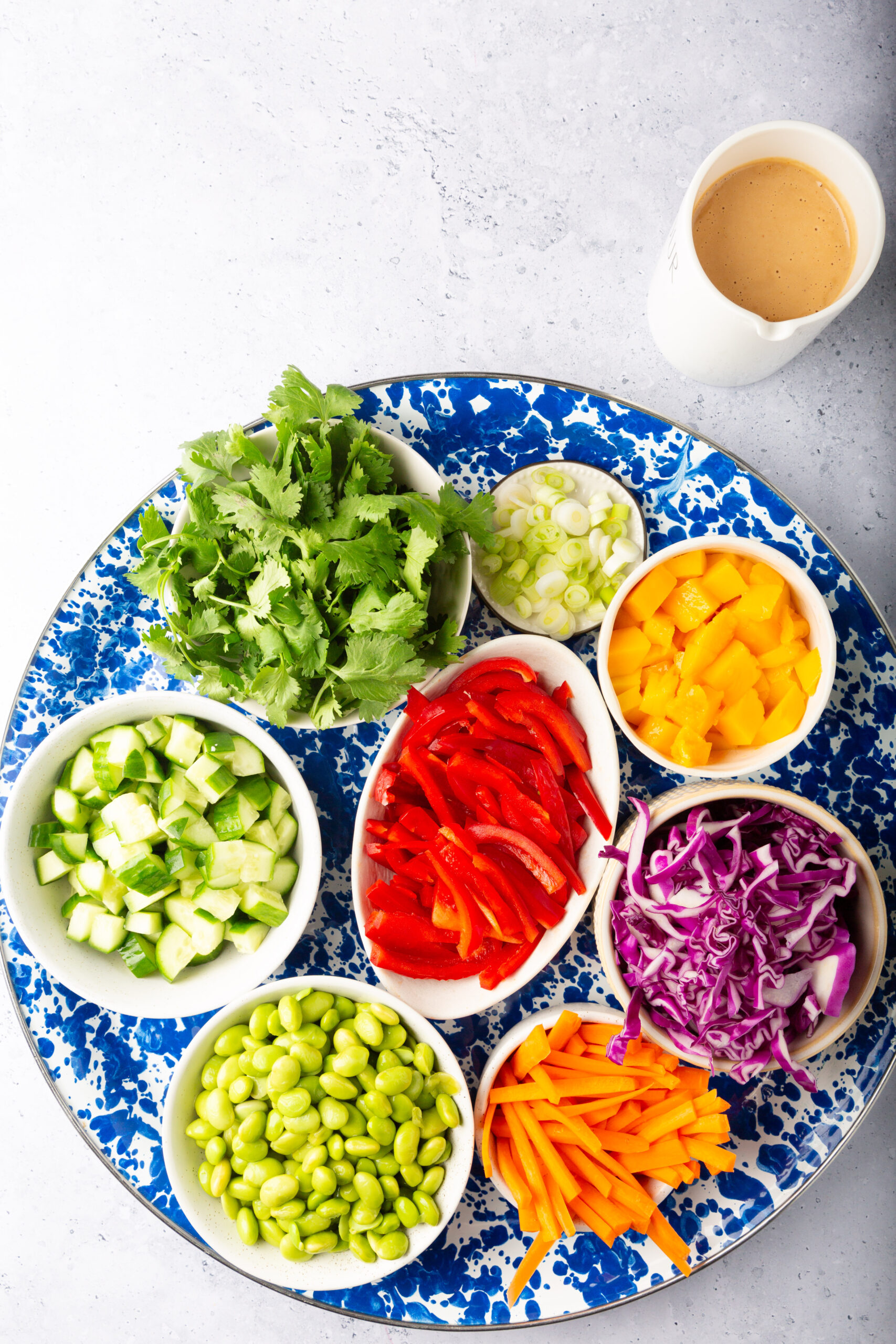 There are several types of vegetables visible. This includes what appears to be thinly sliced red bell peppers, shredded purple cabbage, and possibly some green leafy vegetables.