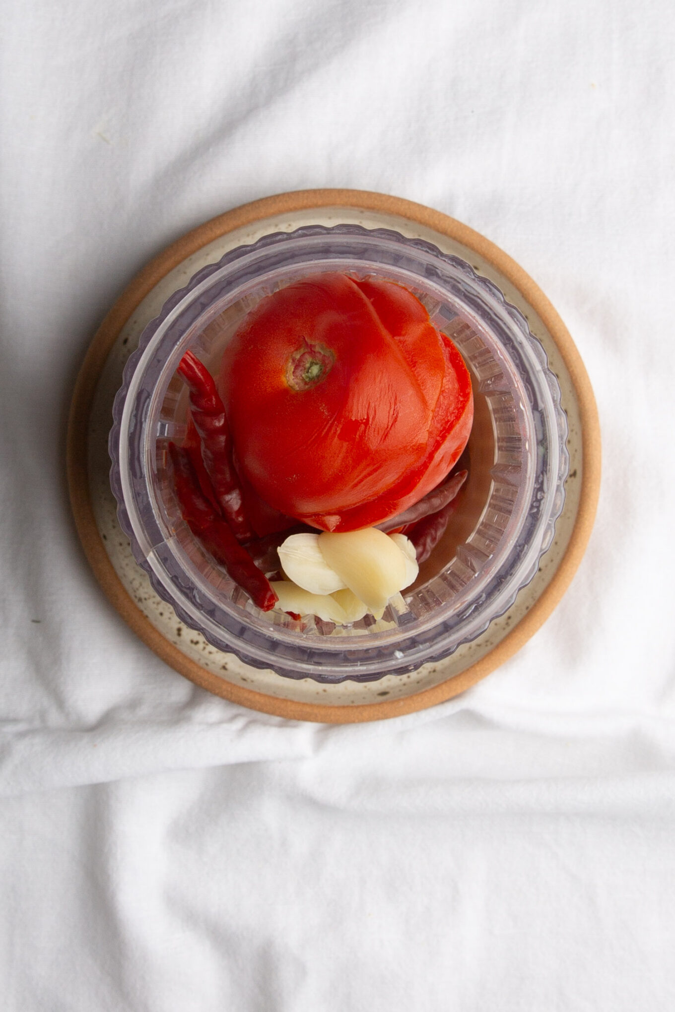 There is a tomato on a plate.