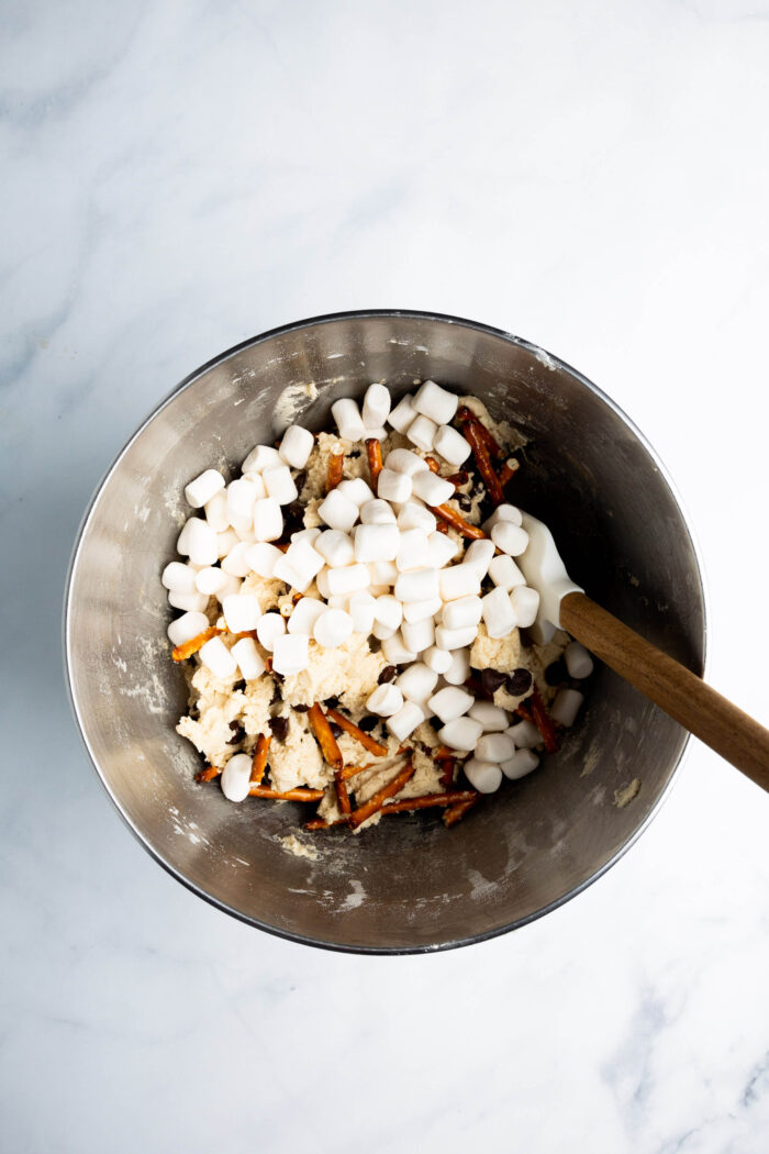 Marshmallows in a bowl with a wooden spoon.