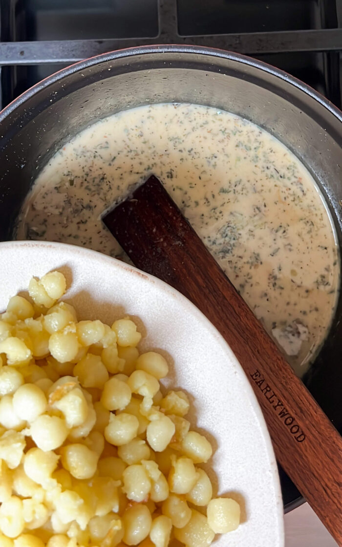 Deliciously creamy vegan macaroni and cheese in a pot on a stove.