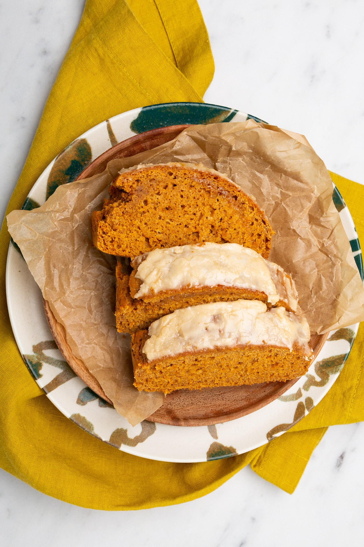 A slice of vegan pumpkin bread sprinkled with spices, served on a plate.