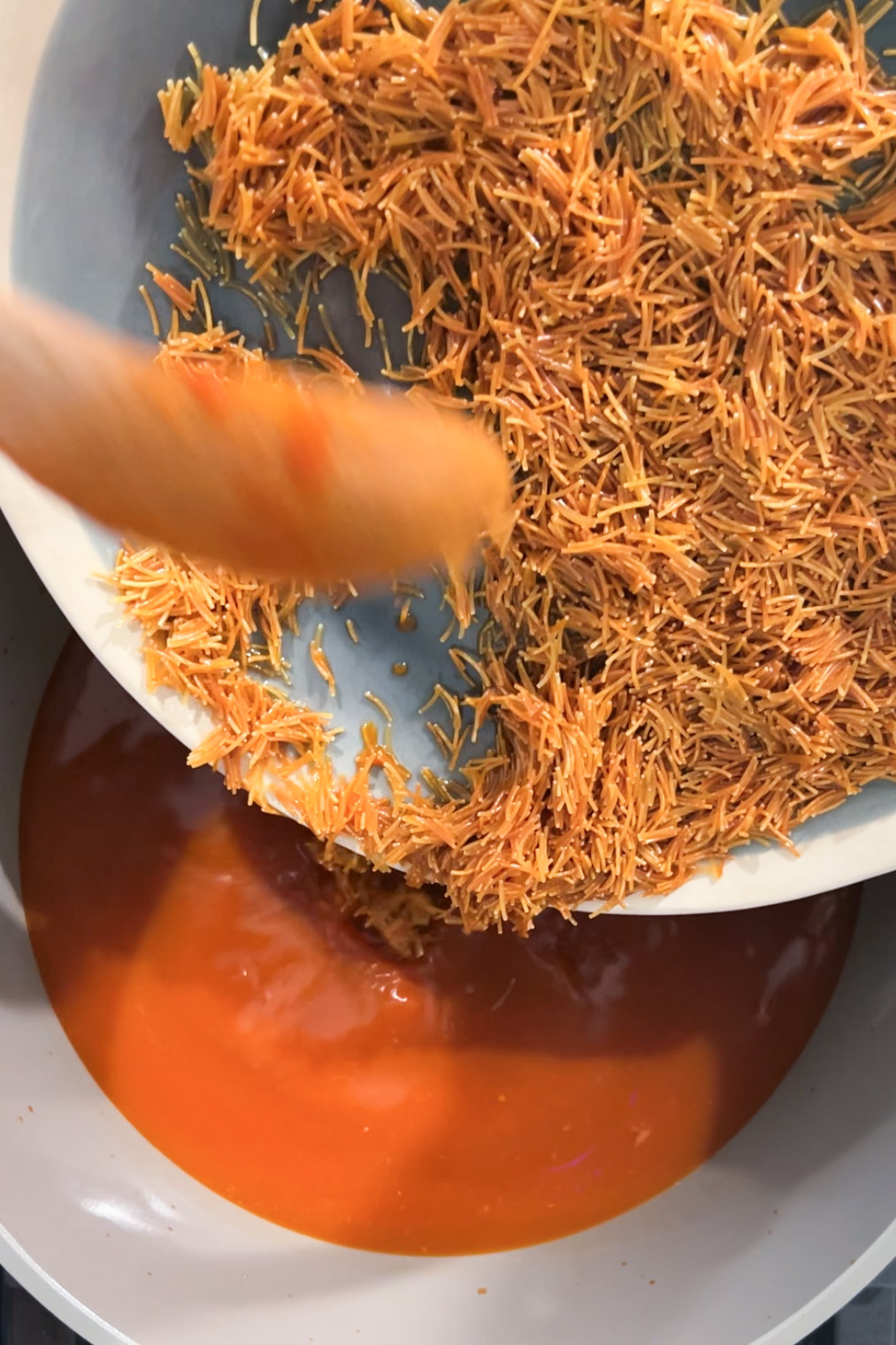 Shredded carrots in a bowl with a spoon.