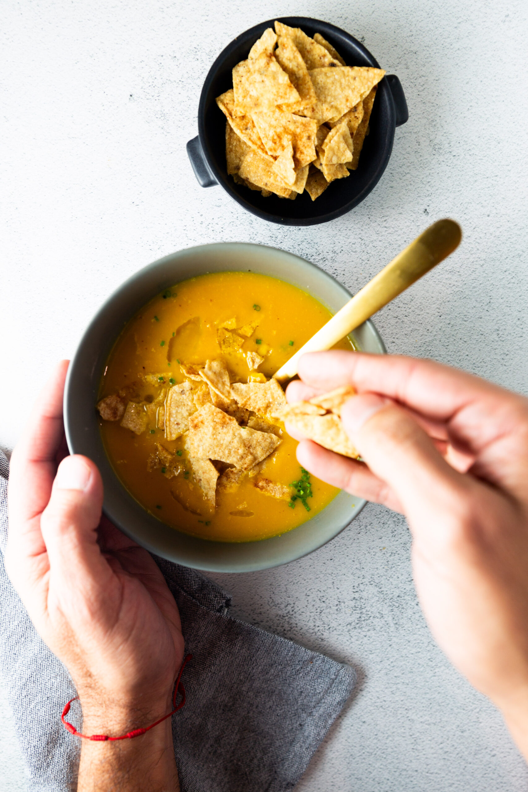 A healthy bowl of Butternut Squash Soup with tortilla chips.