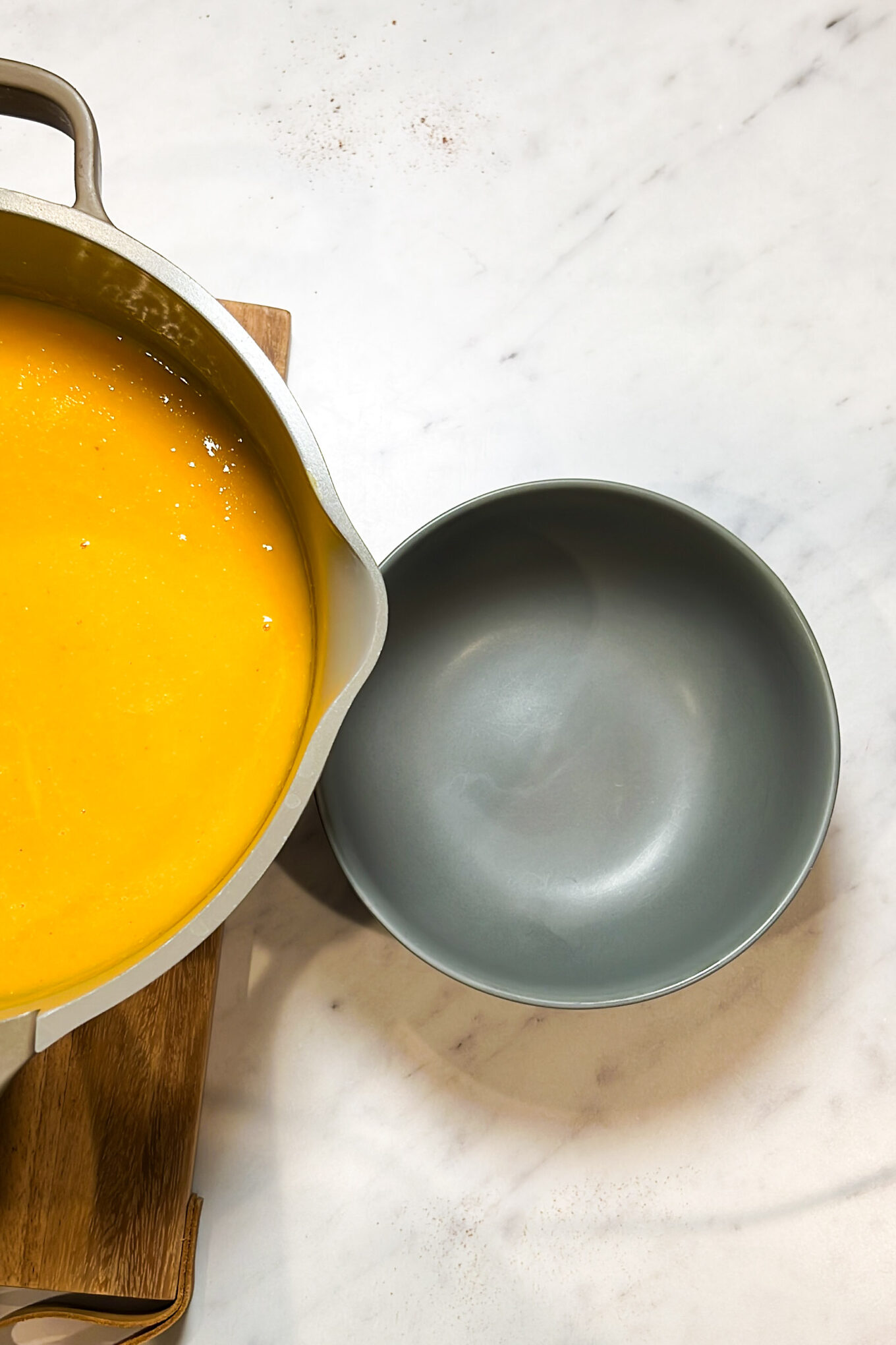 A healthy bowl of Butternut Squash Soup with a spoon sitting on top, which is both easy to make and delicious.