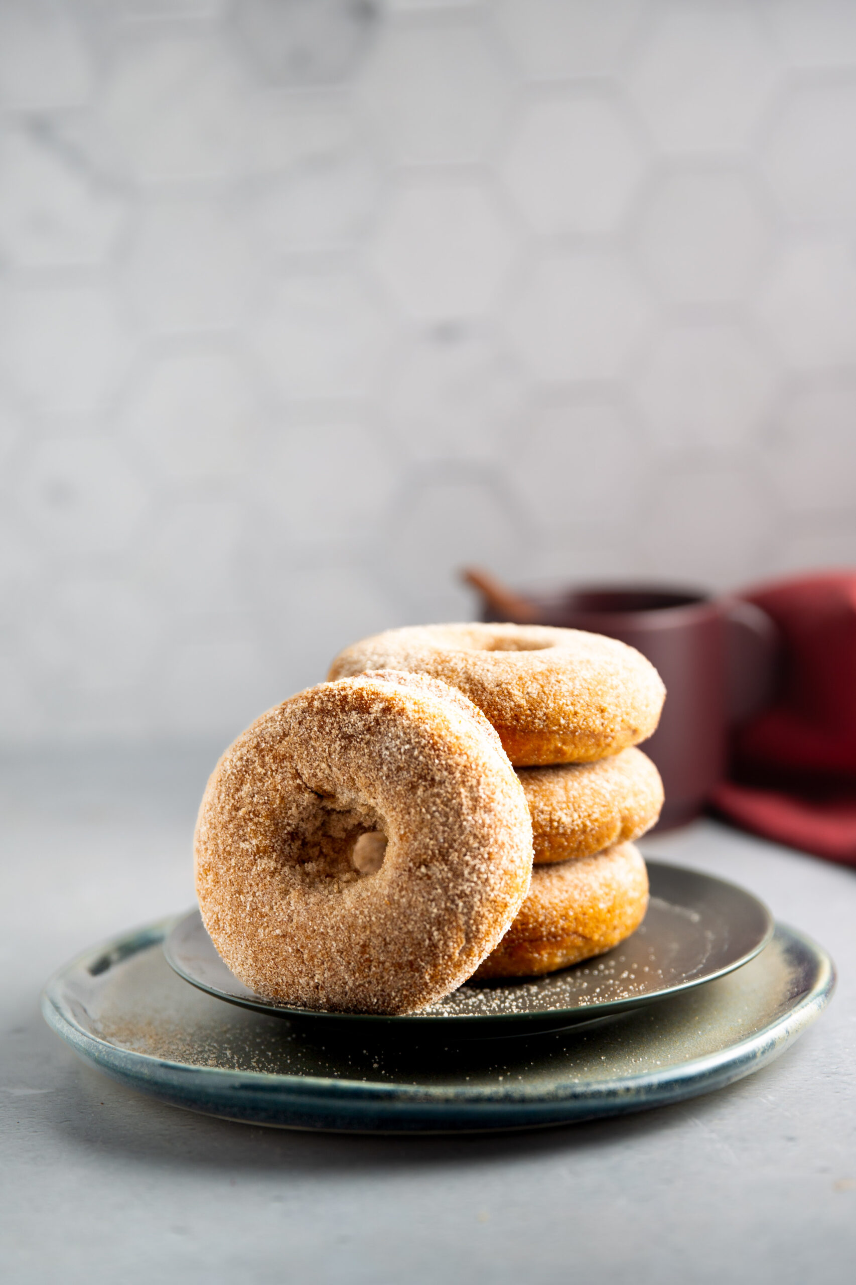 A stack of vegan cinnamon sugar donuts on a plate.