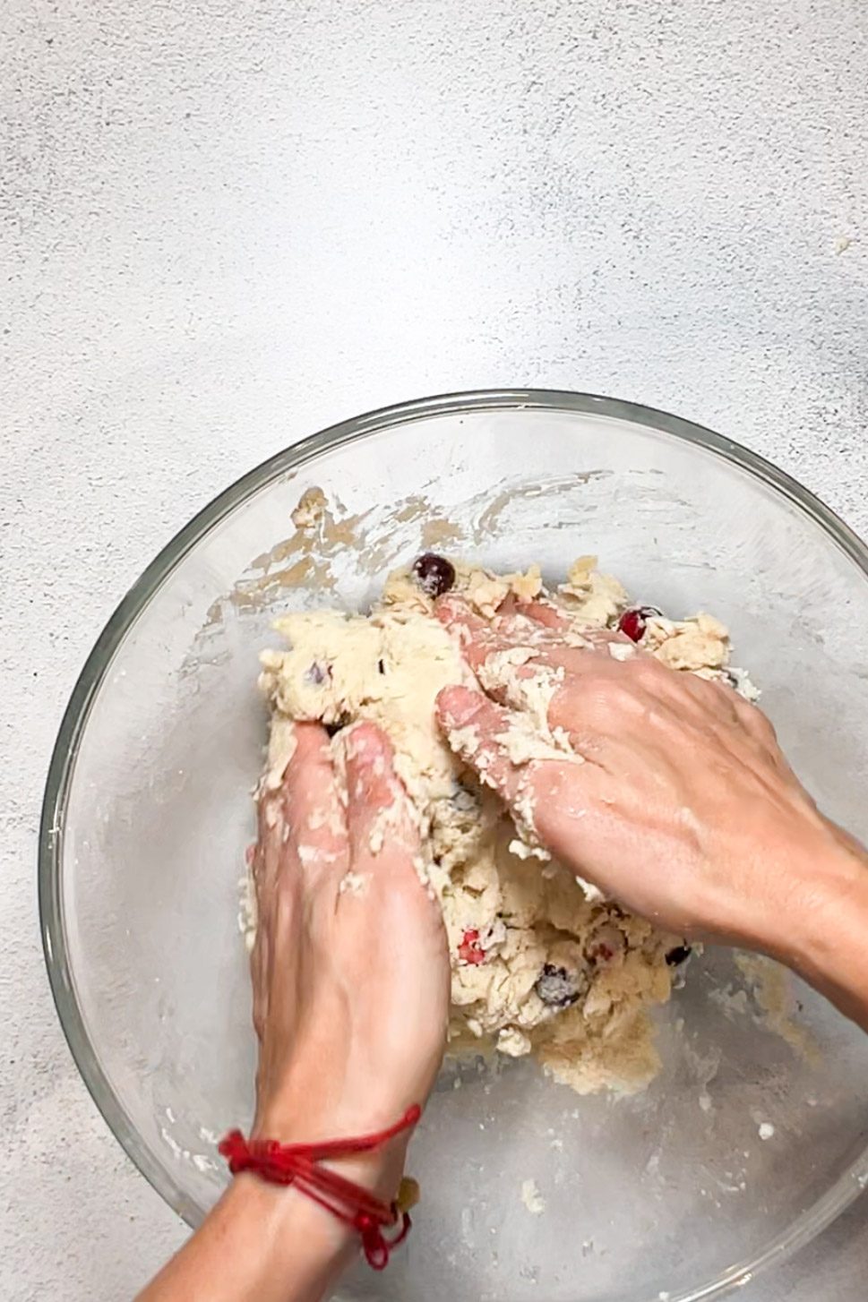 A vegan person mixing cranberry cookie dough in a bowl.