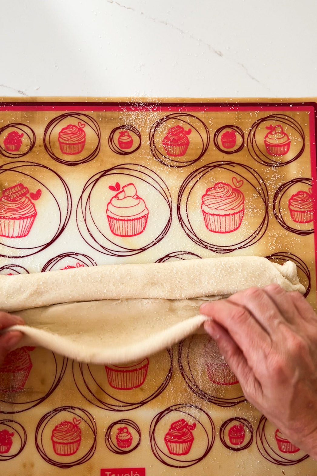 A person using a pastry mat to make vegan cupcakes.