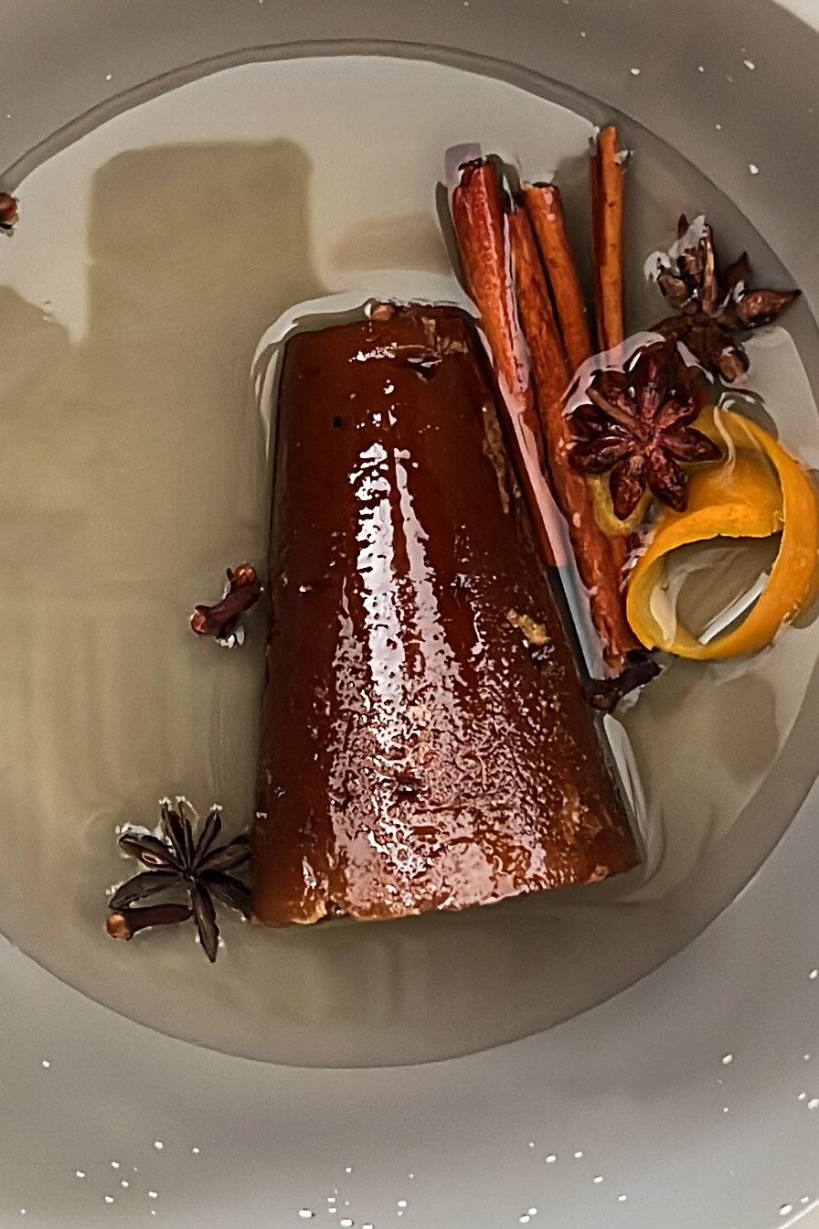 A dish with cinnamon sticks and star anise in a bowl.