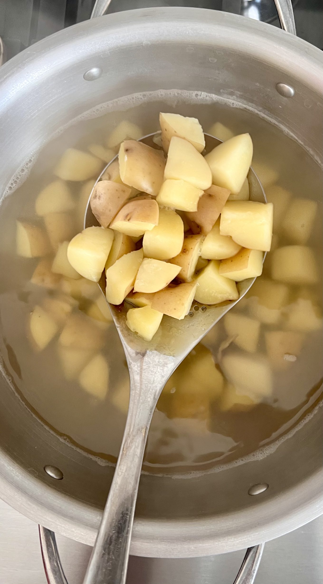A spoon in a pot of potato soup macha.
