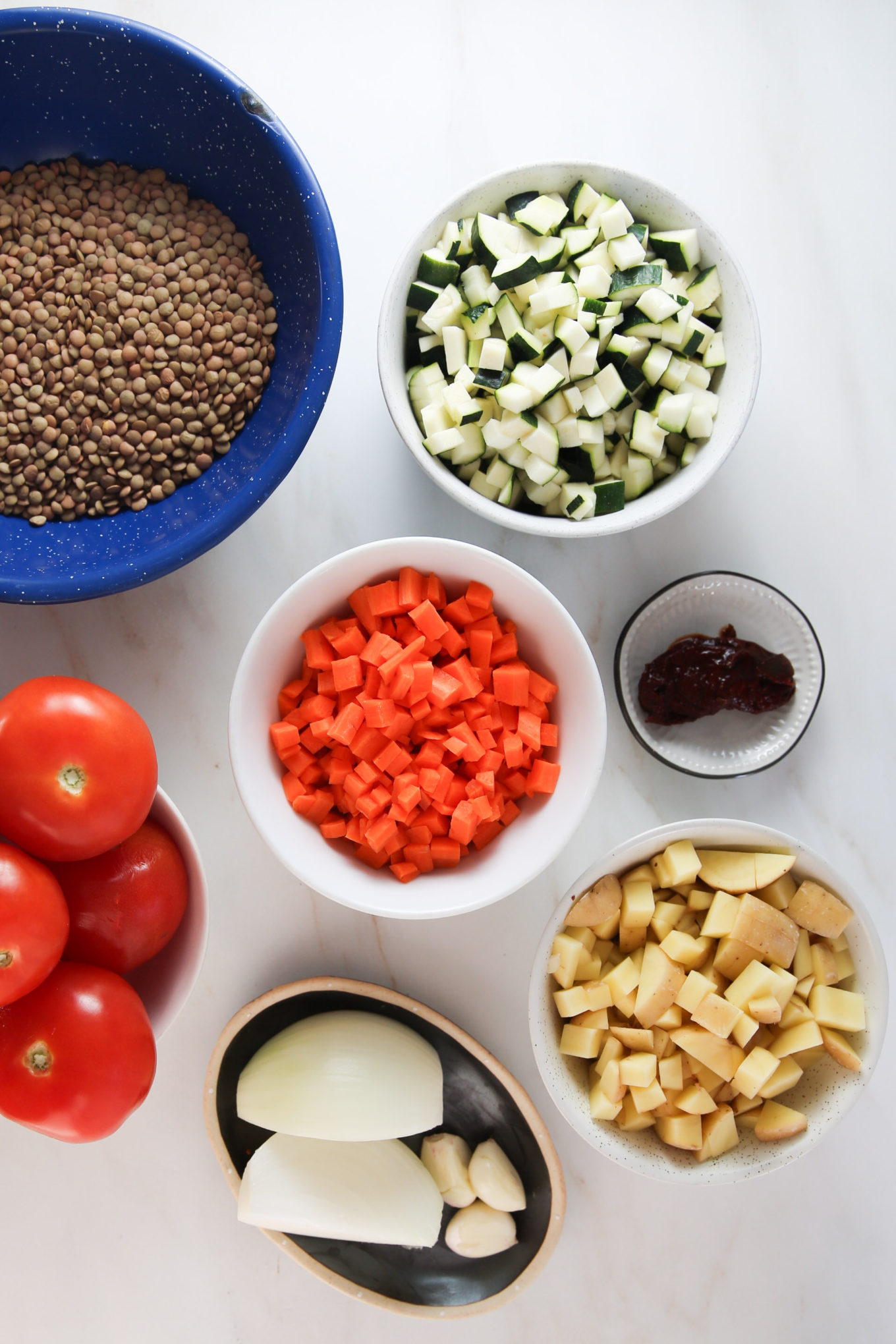 A table is filled with a colorful variety of vegetables, including lentils, for a delicious vegetarian dish.