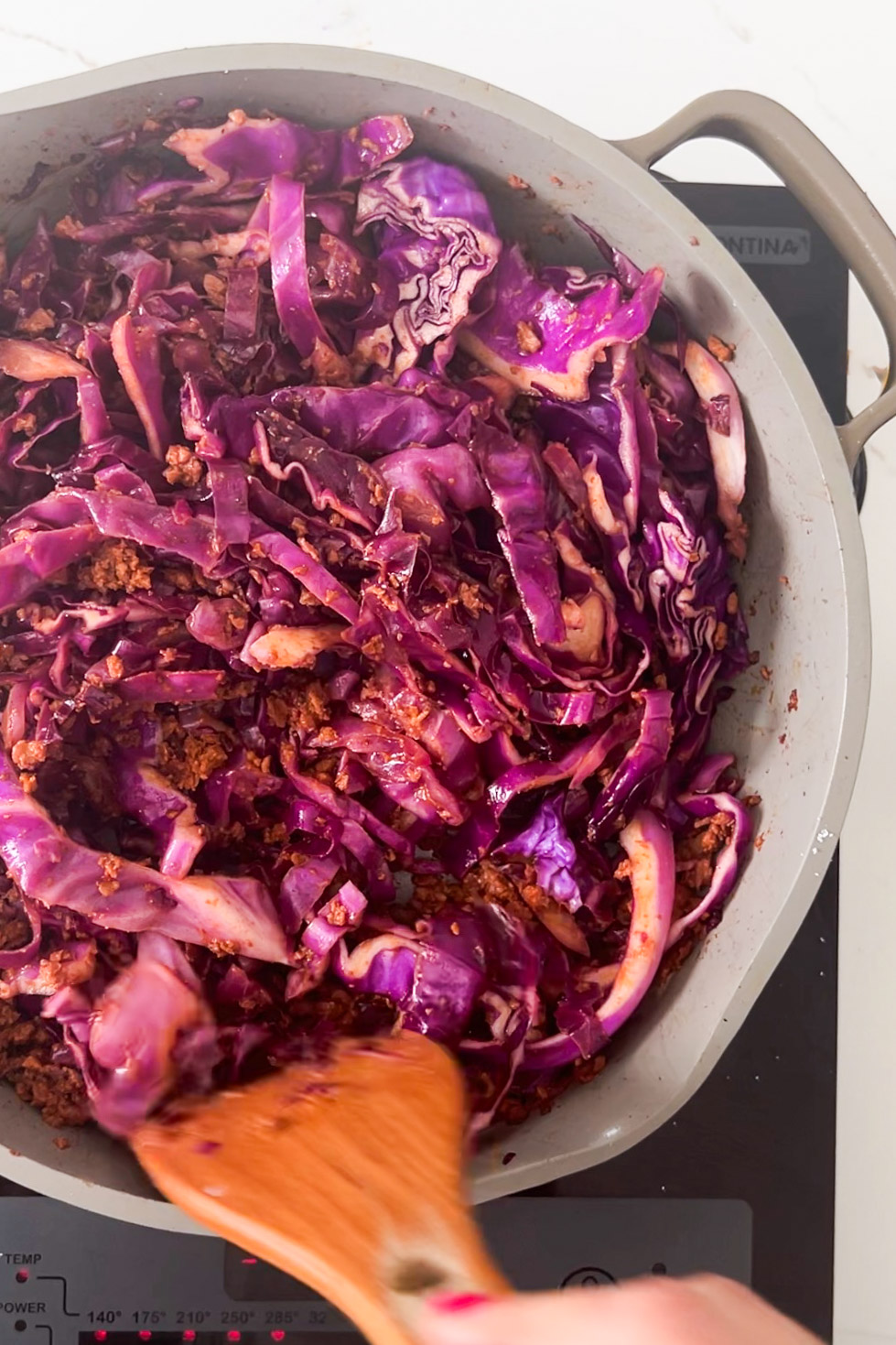 Sliced red cabbage and chorizo in a pan.