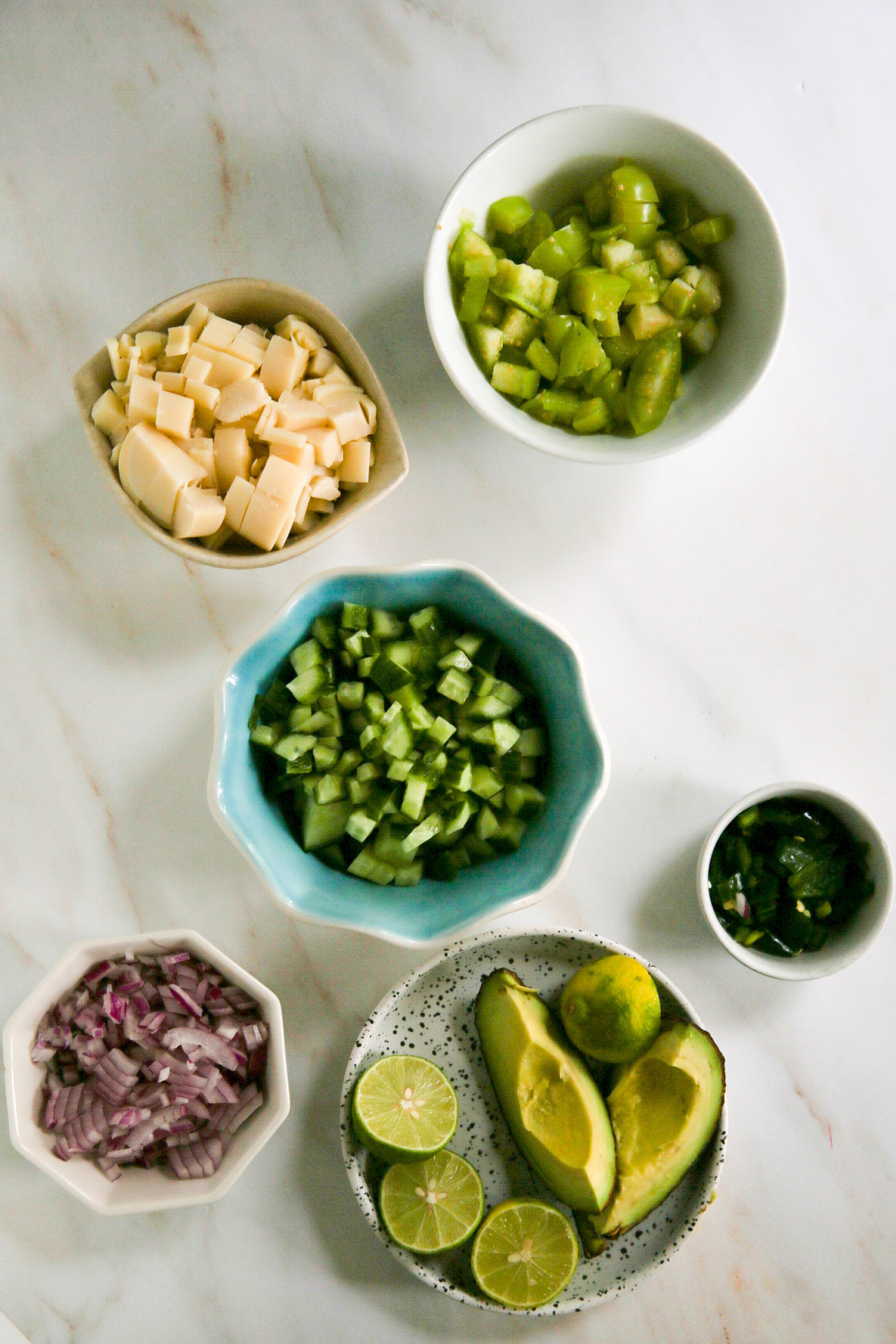 The guacamole ingredients, including the tostadas, are arranged on a table.