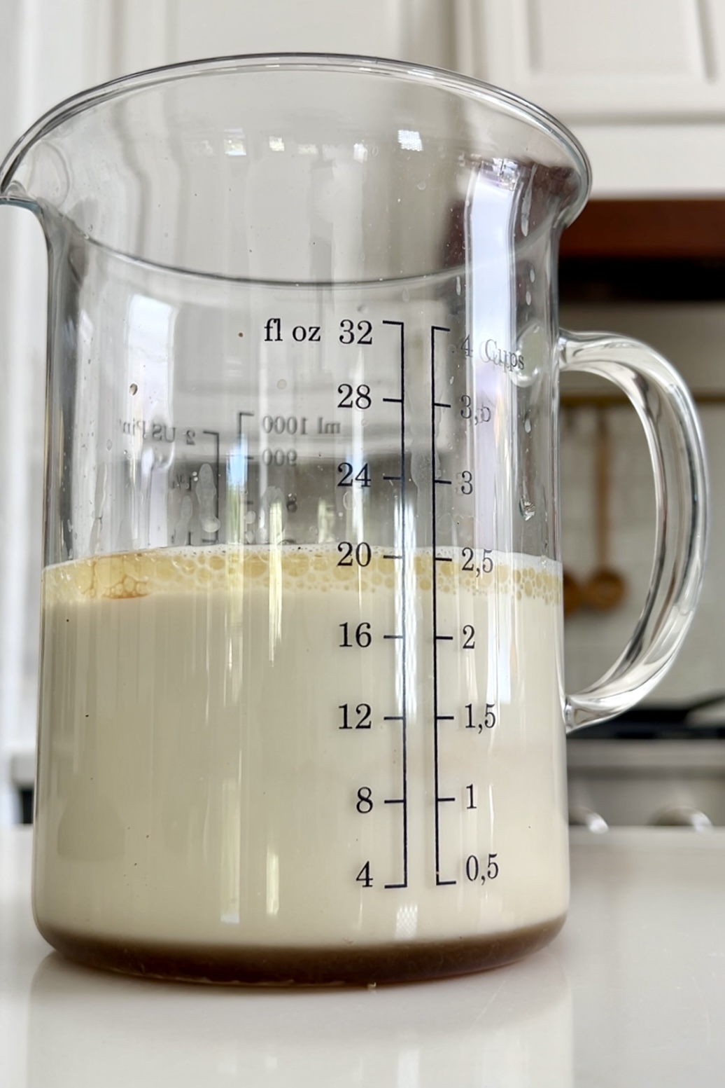 a measuring cup with milk, oil and maple syrup