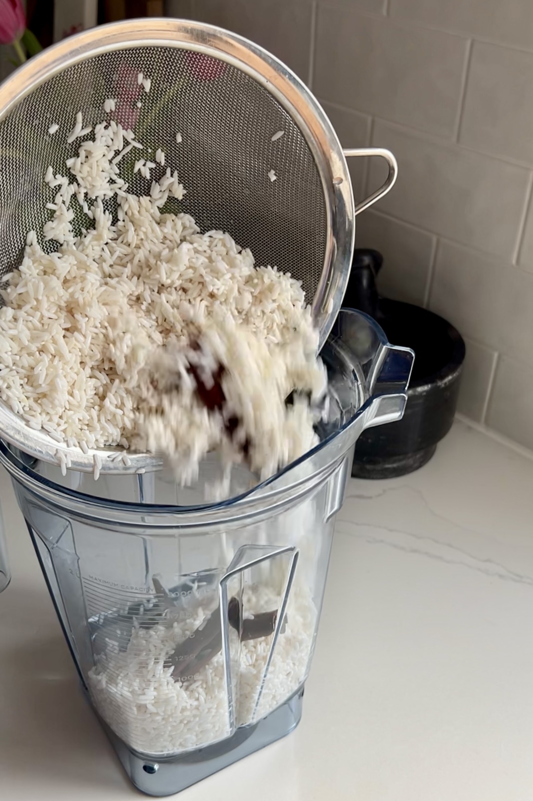 adding soaked rice and cinammon into a blender